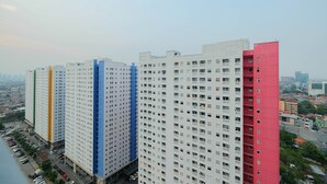 A row of high-rise buildings with uniform balconies and a clear view of the surrounding cityscape. - Modern Studio Apartment 26th on Top of Green Pramuka Mall (Jakarta)