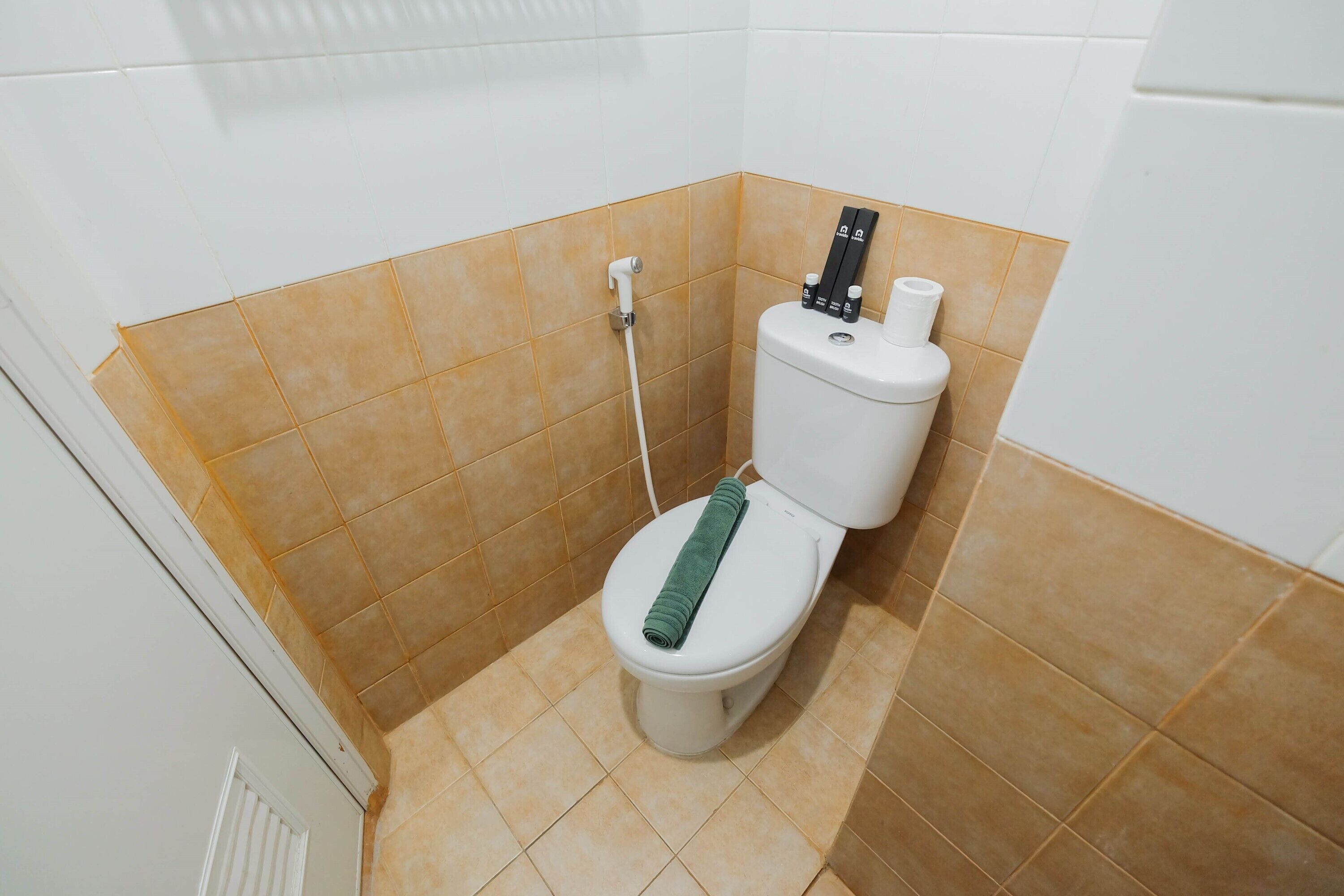 Un baño pequeño con inodoro, ducha y un dispensador de papel higiénico.