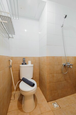 Un baño con inodoro, ducha y toallero.