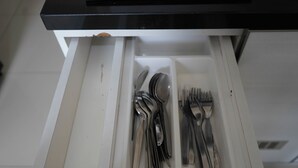 Eine Schublade mit Besteck, darunter Gabeln, Löffel und Messer.