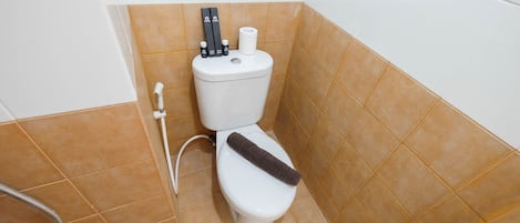 A bathroom with a toilet, a shower, and a towel rack.
