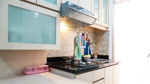 Uma cozinha moderna com fogão a gás, micro-ondas e forno embutido. Há uma pia com torneira e uma janela sobre a pia.