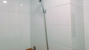 A shower with a chrome fixture and a flexible hose against a tiled wall. - Connected to Mall 2BR Apartment at Green Pramuka City (Jakarta)