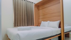 A bed with a wooden frame and a storage box underneath. - Connected to Mall 2BR Apartment at Green Pramuka City (Jakarta)
