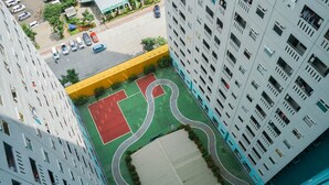A high-rise building with multiple balconies and a rooftop garden.