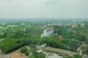 An aerial view of a campus with a prominent building, green spaces, and a road.
