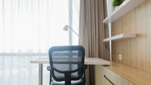 A modern office space with a desk, chair, and shelves. - Studio Apartment with Mall Access at U Residence (Curug)