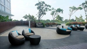 A rooftop patio with wicker furniture and planters. - Classy Studio Apartment at U Residence (Curug)