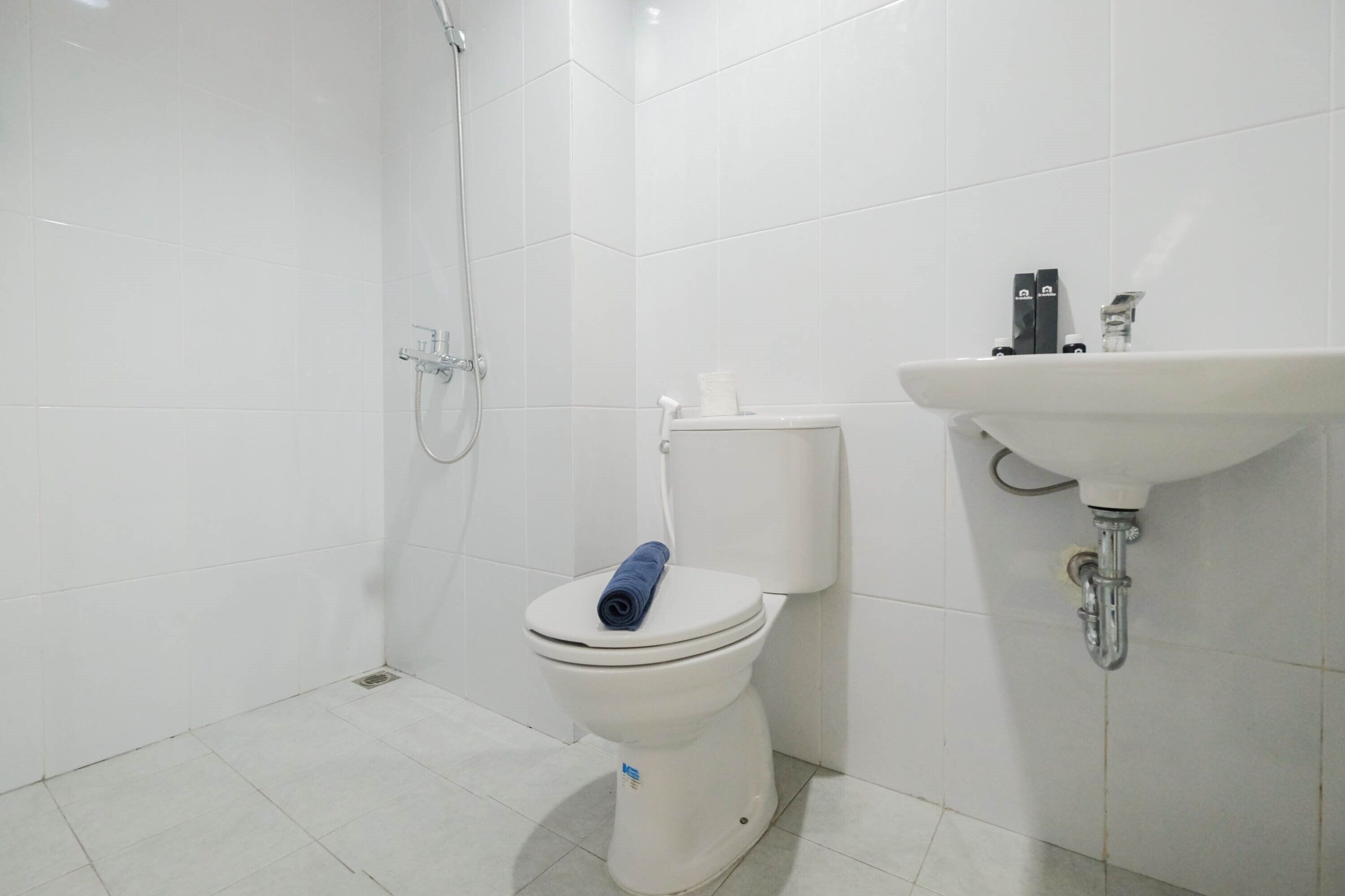 A bathroom with a white toilet, a shower, and a sink.