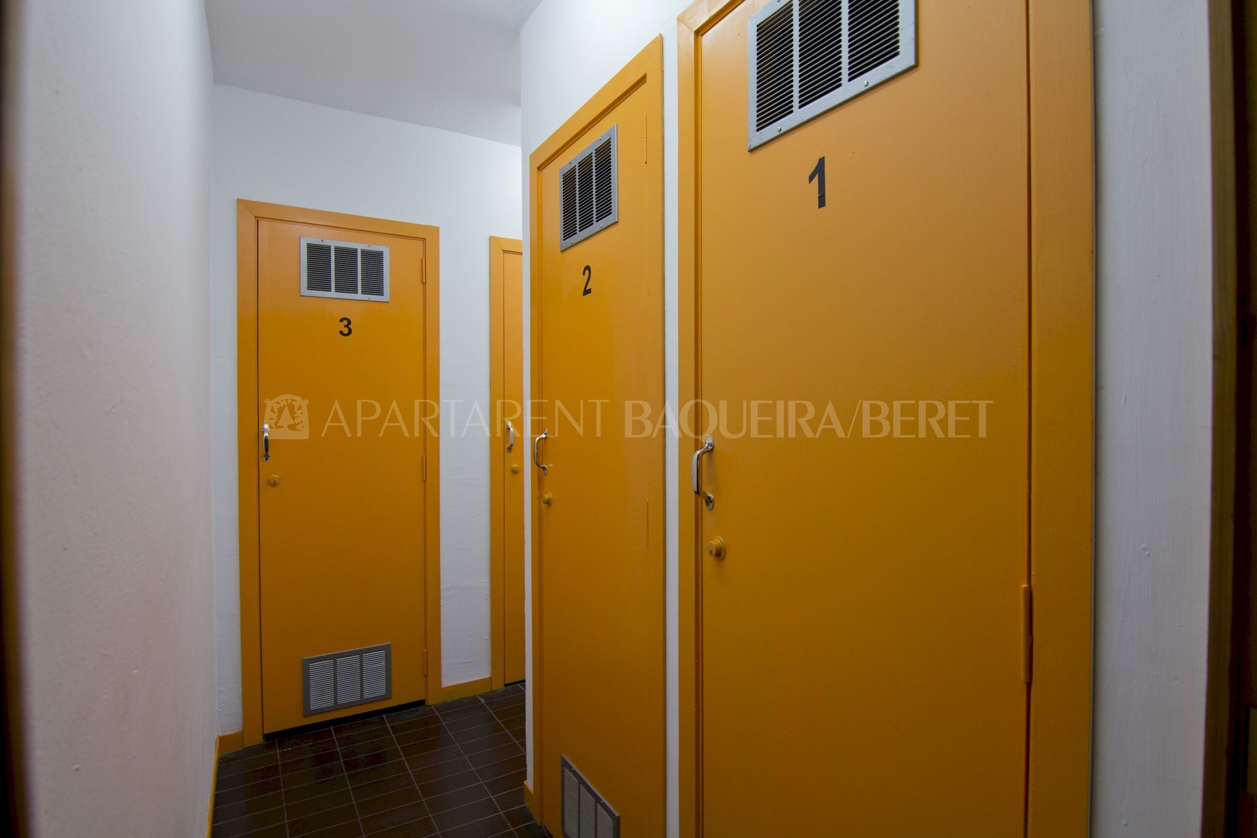 A hallway with three yellow doors, each marked with a number.