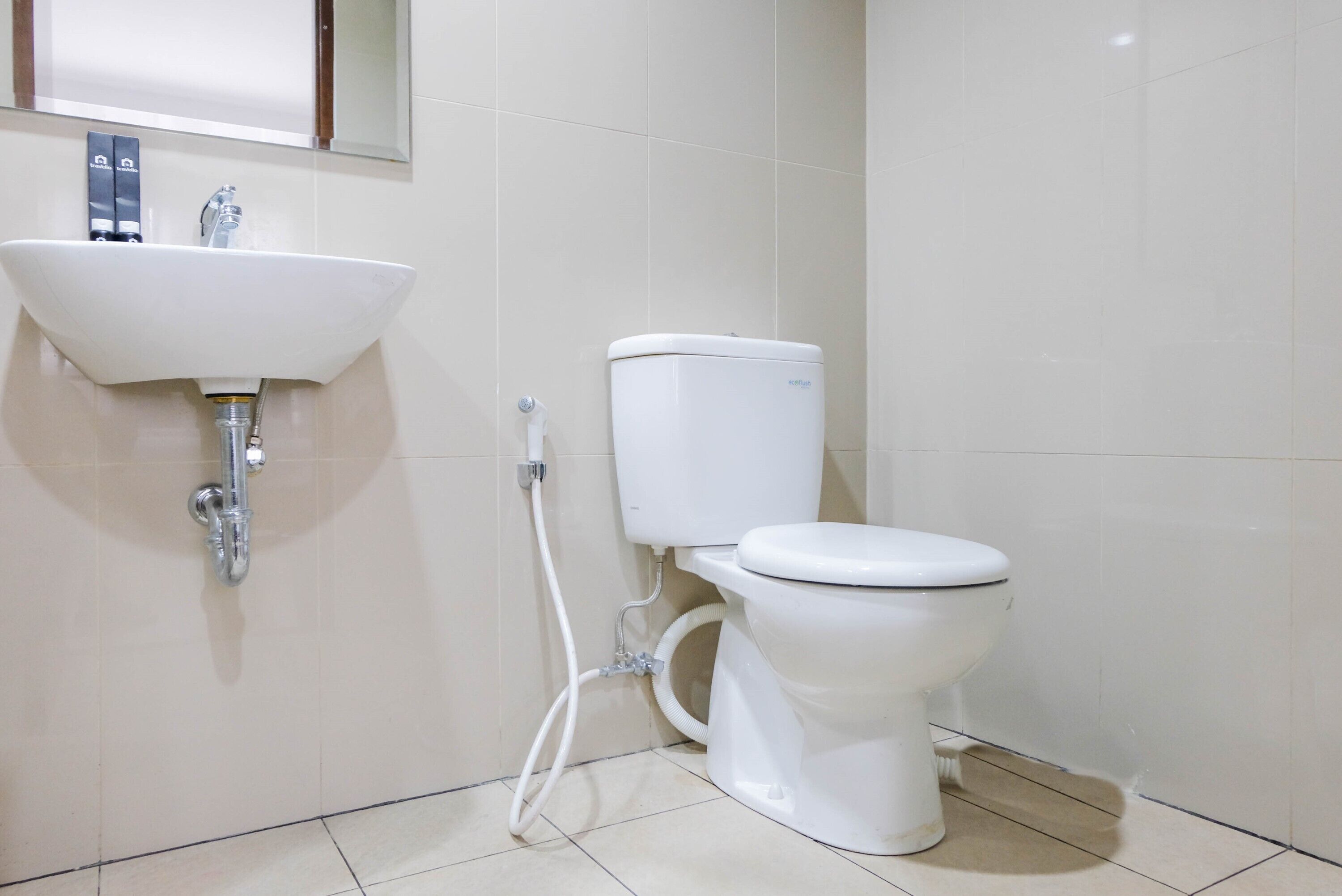 A bathroom with a white sink, toilet, and tiled walls.