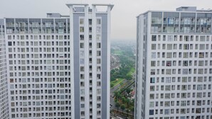Un edificio alto con una cuadrícula de ventanas y balcones, visto desde lejos.
