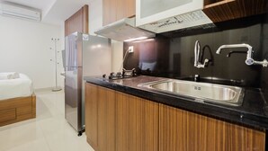 Una cocina moderna con armarios de madera, un fregadero de acero inoxidable y un horno empotrado.