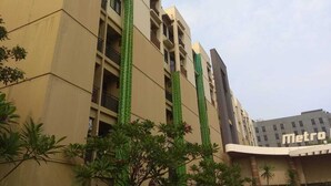A multi-story building with balconies and a Metro sign in the background. - New Furnished 2BR Apartment @ Mutiara Bekasi (Bekasi)