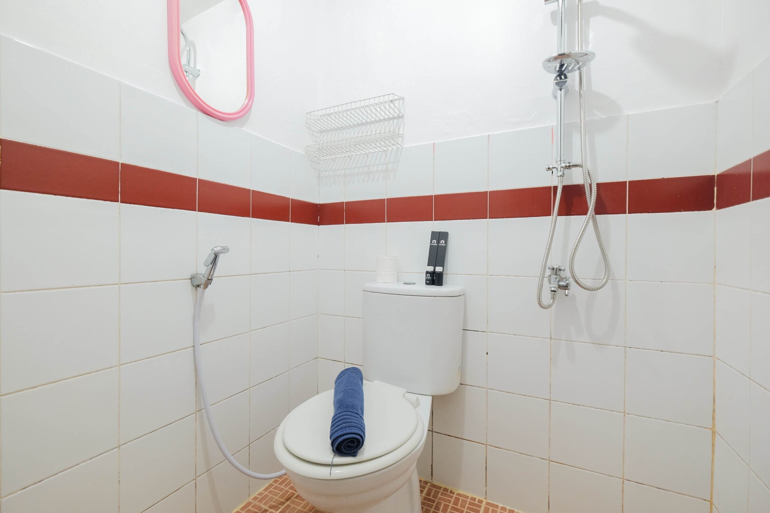 Un baño con inodoro, ducha y secamanos.