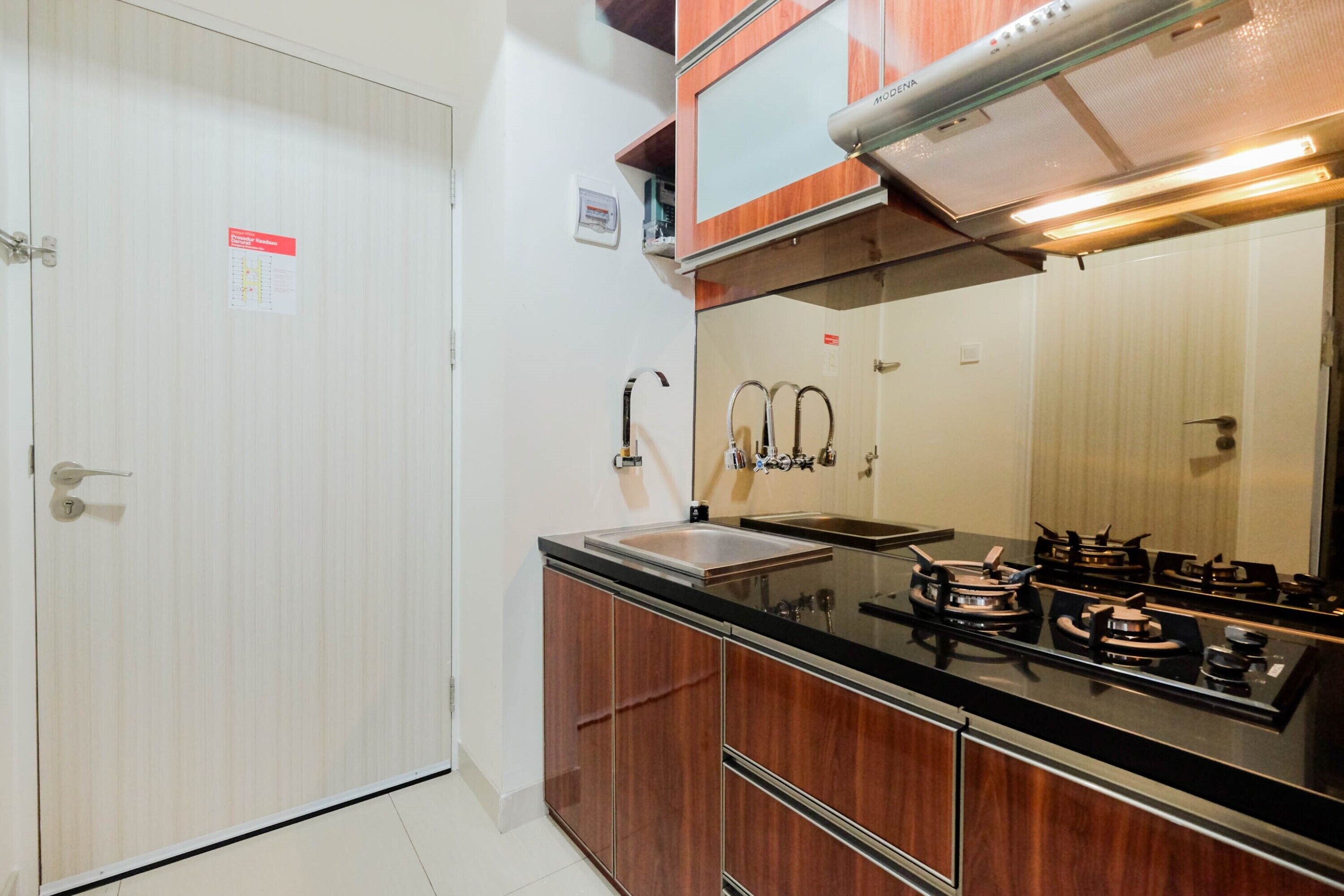 A compact kitchen with a stove, sink, and cabinets.