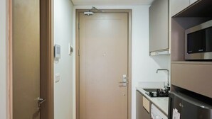 A compact kitchen with a washing machine, a microwave, and a small countertop.