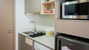A compact kitchen with a microwave, gas stove, and a dishwasher.