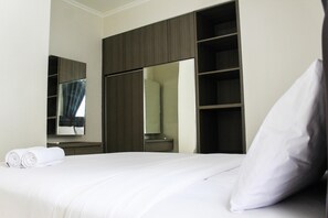 A hotel room with a neatly made bed, a large mirror, and a wardrobe with shelves. - New Furnished 2BR Apartment at Silkwood Residence (Tangerang)