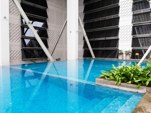 A modern indoor pool with geometric wall patterns and a clear blue pool. - Luxurious and Comfy 2BR Paddington Heights Alam Sutera Apartment (Tangerang)