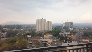 Un paisaje urbano con varios edificios altos, incluyendo una torre destacada y una obra en construcción.