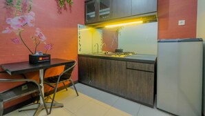 Une cuisine compacte avec un coin repas, comprenant un évier, une cuisinière et un réfrigérateur.