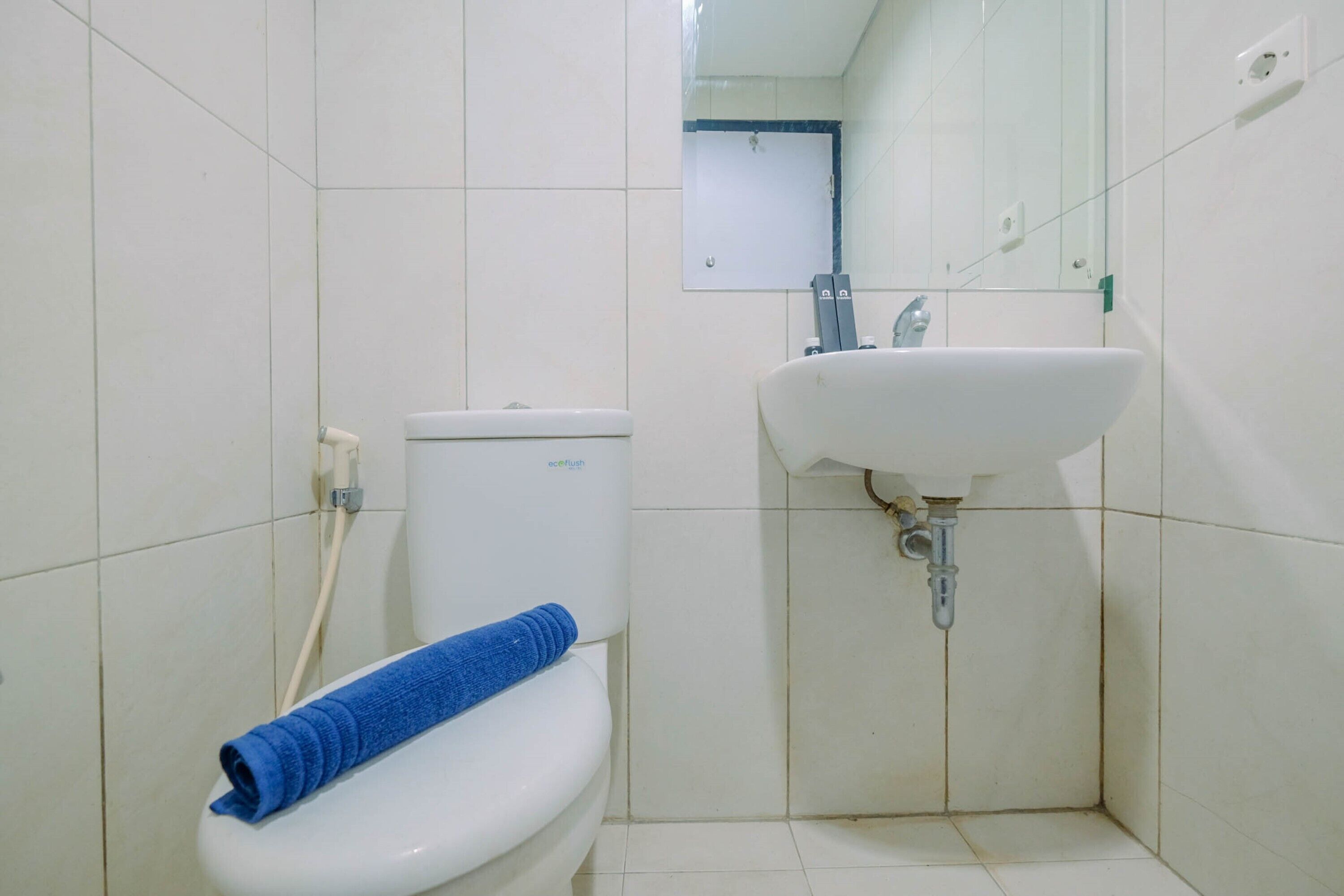 Un baño pequeño con inodoro, lavamanos y espejo.