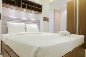 A neatly made bed with white linens and two rolled towels on the side. - Best Deal 3BR Bassura Apartment (Jakarta)