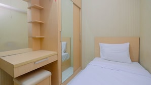 A bedroom with a bed, a desk, a mirror, and a wardrobe. - Warm and Homey 2BR Apartment at Kebagusan City (Jakarta)