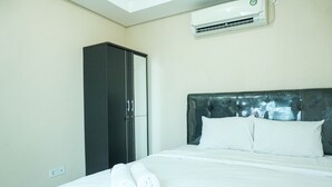 A hotel room with a bed, a wardrobe, and an air conditioning unit. - 2Bedroom Sky Terrace Apartment with Pool View (Jakarta)