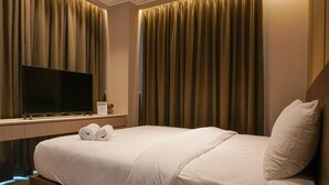 A hotel room with a large bed, a flat-screen TV, and curtains. - Cozy and Comfy 2BR Citralake Suites Apartment (Jakarta)