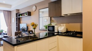 A modern kitchen with a black countertop, white cabinets, a microwave, toaster, and a gas stove.