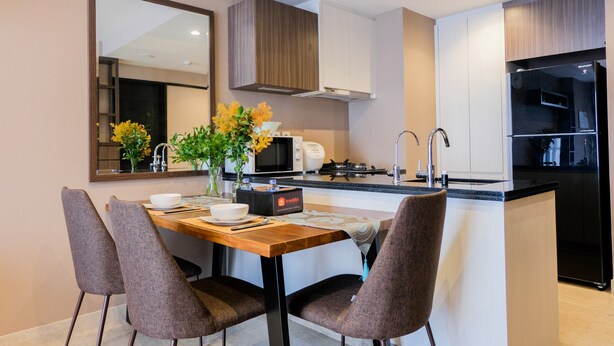 A modern kitchen with a central island, white cabinetry, and a microwave.