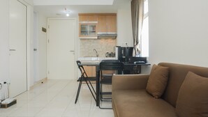 A compact living space with a kitchenette, a dining area, and a sofa. - Comfy 2BR Apartment @ Springlake Summarecon (Bekasi)