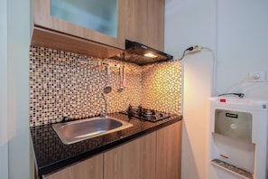 Kamer | Privékeuken | Een koelkast, een kookplaat, een waterkoker, kookgerei, borden en bestek