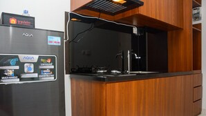 A kitchen with a stainless steel refrigerator and a wooden countertop. - Comfy Studio Room at Patraland Urbano Apartment (Bekasi)