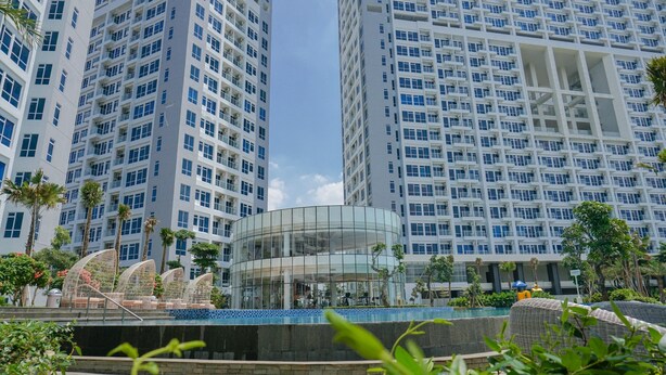 Un hôtel moderne doté d’immeubles de grande hauteur, d’un atrium en verre et d’un espace piscine.