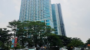 A tall, modern building with a grid of windows and a flat roof. - Chic Brooklyn Alam Sutera Studio Apartment By Travelio (South Tangerang)