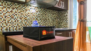 A kitchen counter with a black bag labeled 'travelio' and a water bottle. - Comfortable and Tranquil 2BR Apartment at Green Pramuka By Travelio (Jakarta)