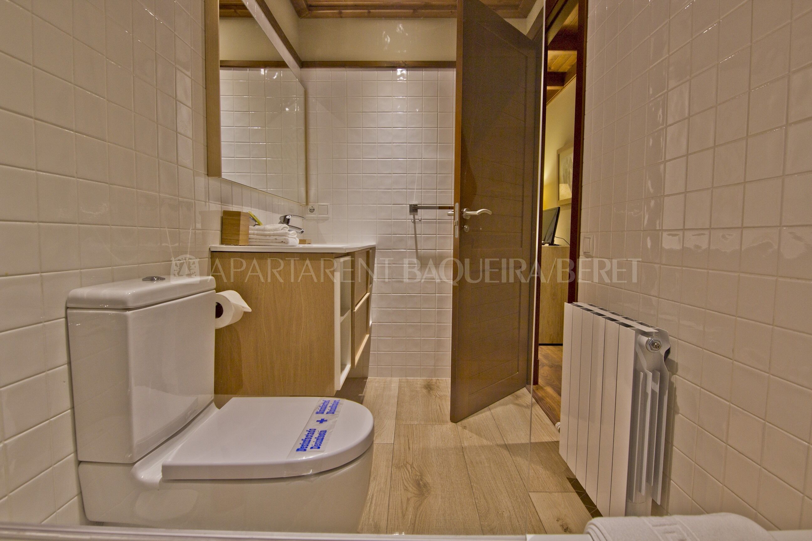 A modern bathroom with a toilet, sink, and mirror.
