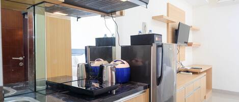 A modern kitchen with stainless steel appliances, a glass cooktop, and wooden cabinets.
