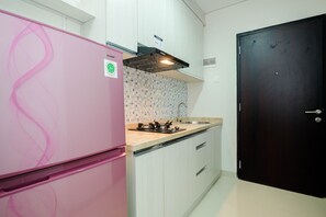 Room | Private kitchen | Fridge, stovetop, cookware/dishes/utensils - Cozy and Modern 1BR Apartment at Atlanta Residences By Travelio (Depok)