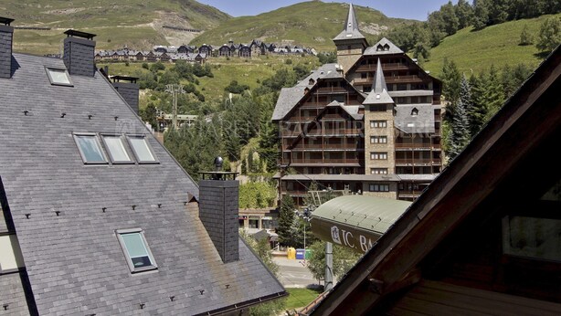 A traditional chalet-style building with multiple balconies and a steeply pitched roof, surrounded by a mountainous landscape. - Sendrosa - Val de Ruda (Baqueira)