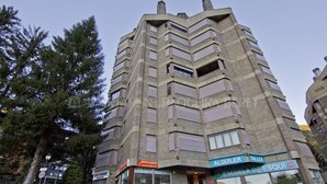 A multi-story building with a unique angular design, featuring a storefront with signs for 'Montplay Baguera' and 'Alquiler Taller'.