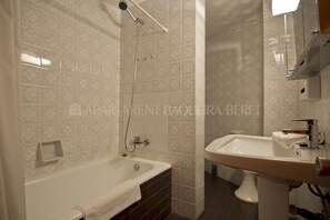Un baño con bañera, lavamanos y ducha.