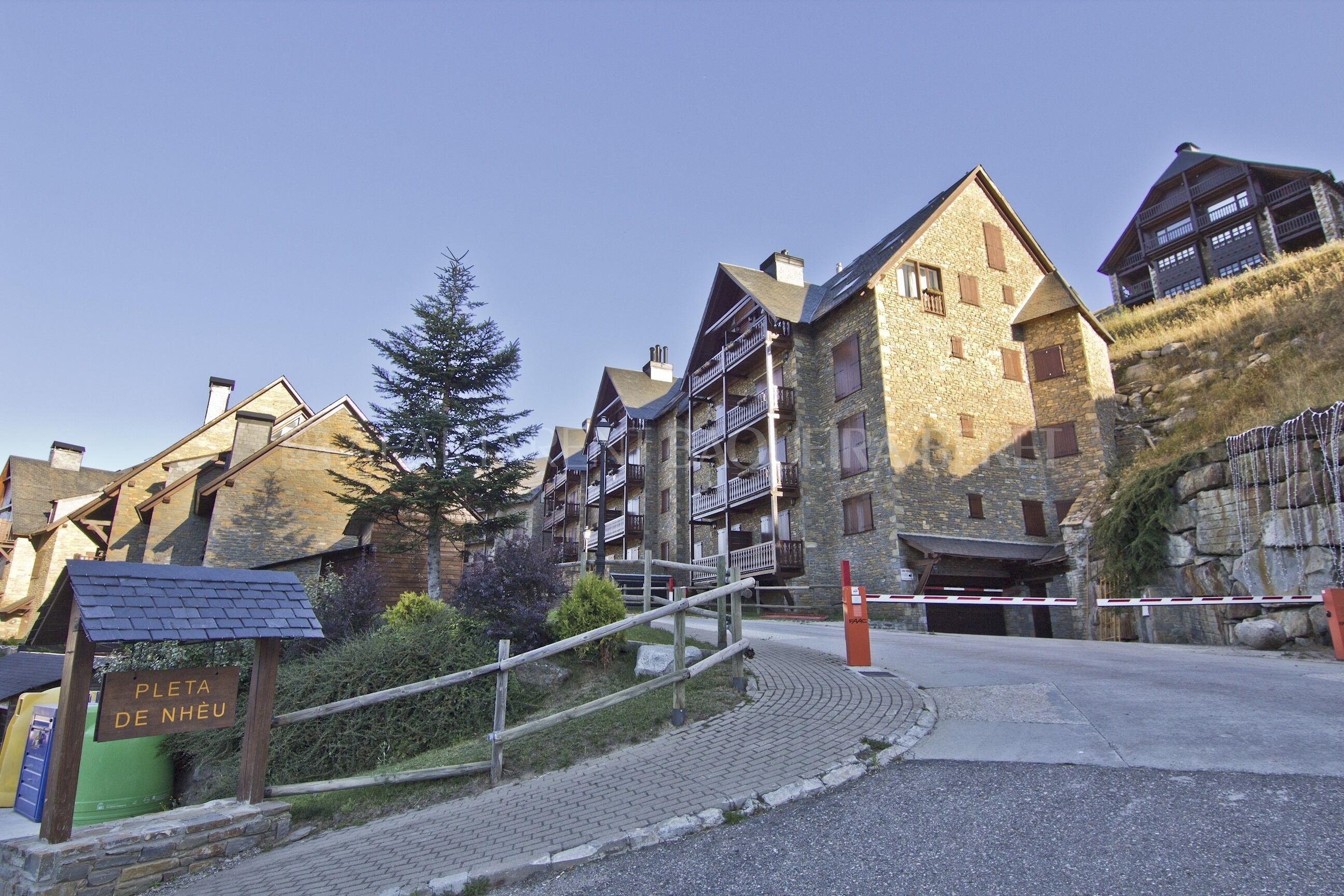 A traditional stone building with multiple balconies and a sign indicating a parking area.