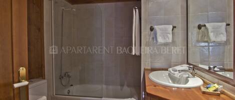 A bathroom with a shower, toilet, and sink.