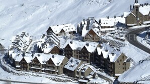 A snow-covered village with traditional wooden houses, a church, and a ski lift. - Azor - Pleta de Nheu (Naut Aran)