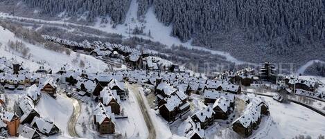 Un pueblo cubierto de nieve con casas de madera y un camino sinuoso.
