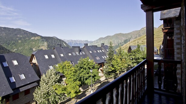 A mountain village with traditional chalet-style buildings, a wooden balcony, and a clear view of the surrounding hills. - Azor - Pleta de Nheu (Naut Aran)